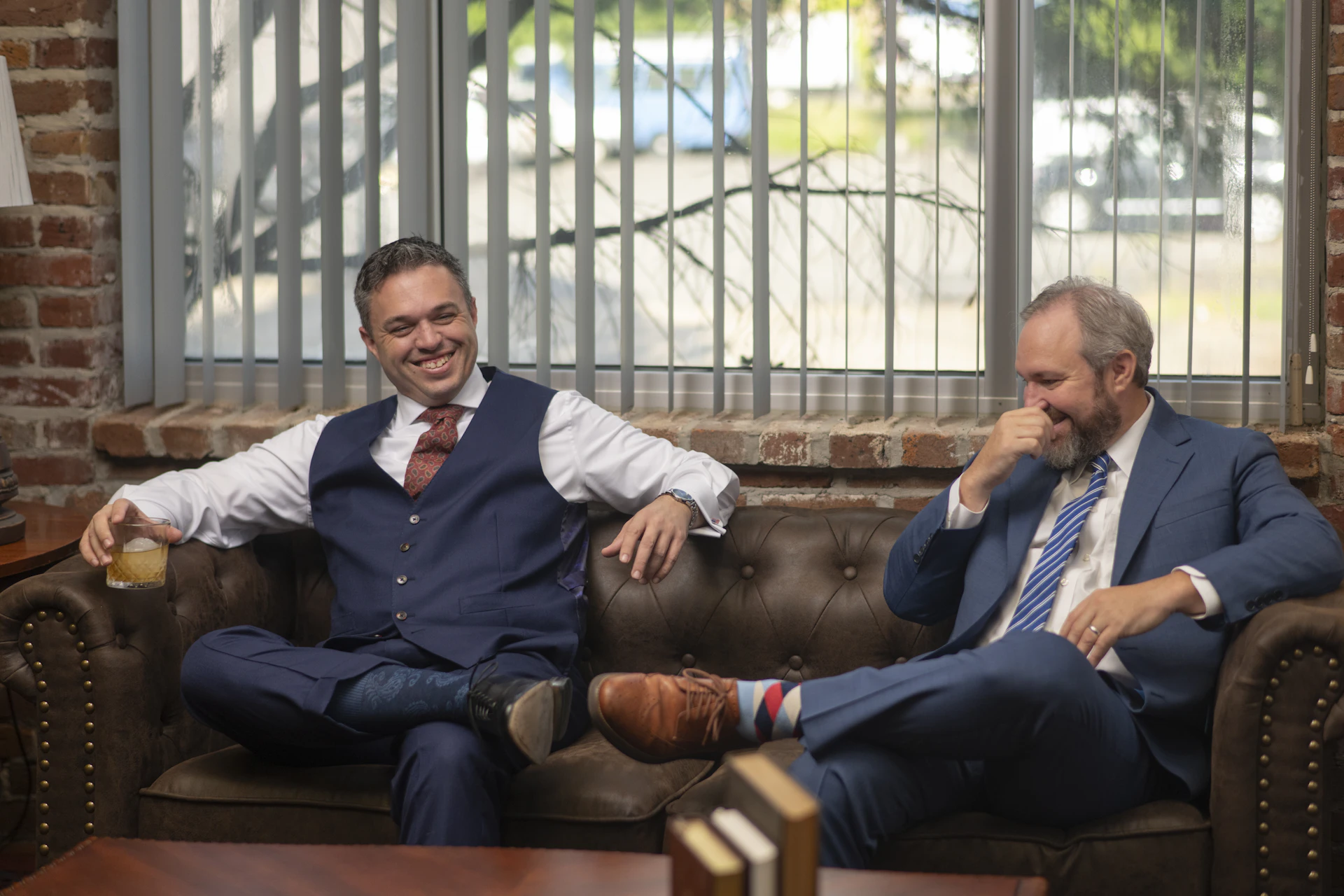 Two Parker-Baker Law attorneys share a relaxed conversation in the office, reflecting a strong professional partnership. The image highlights the firm's approachable team and collaborative culture.